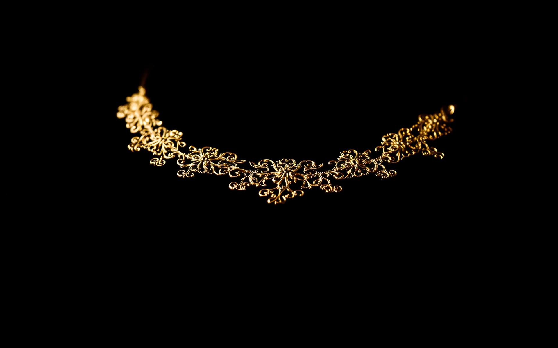 Gold jewellery on black backdrop